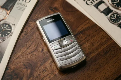 Nokia 8800 en acier inoxydable posé sur une surface en bois de noyer, vue du dessus, ambiance collection luxe